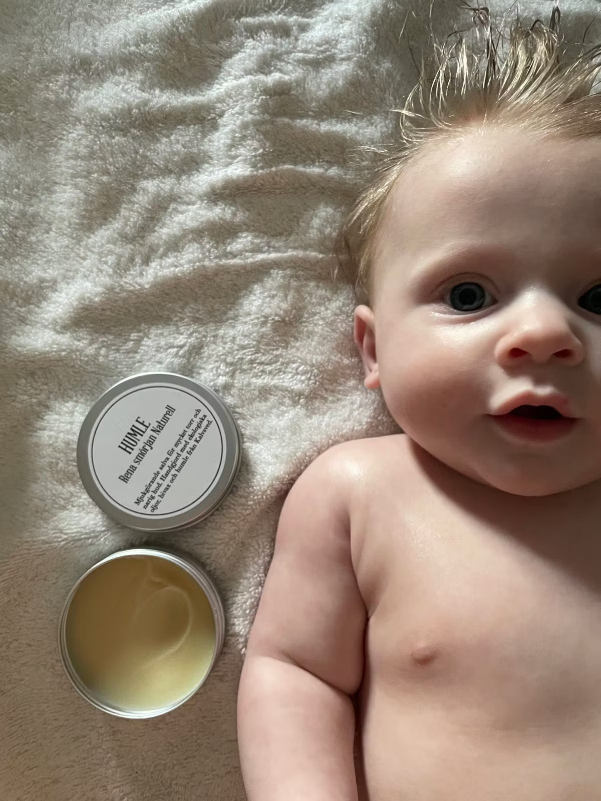 HUMLE Rena Smörjan Naturell, doftfri humlesalva bredvid baby på filt